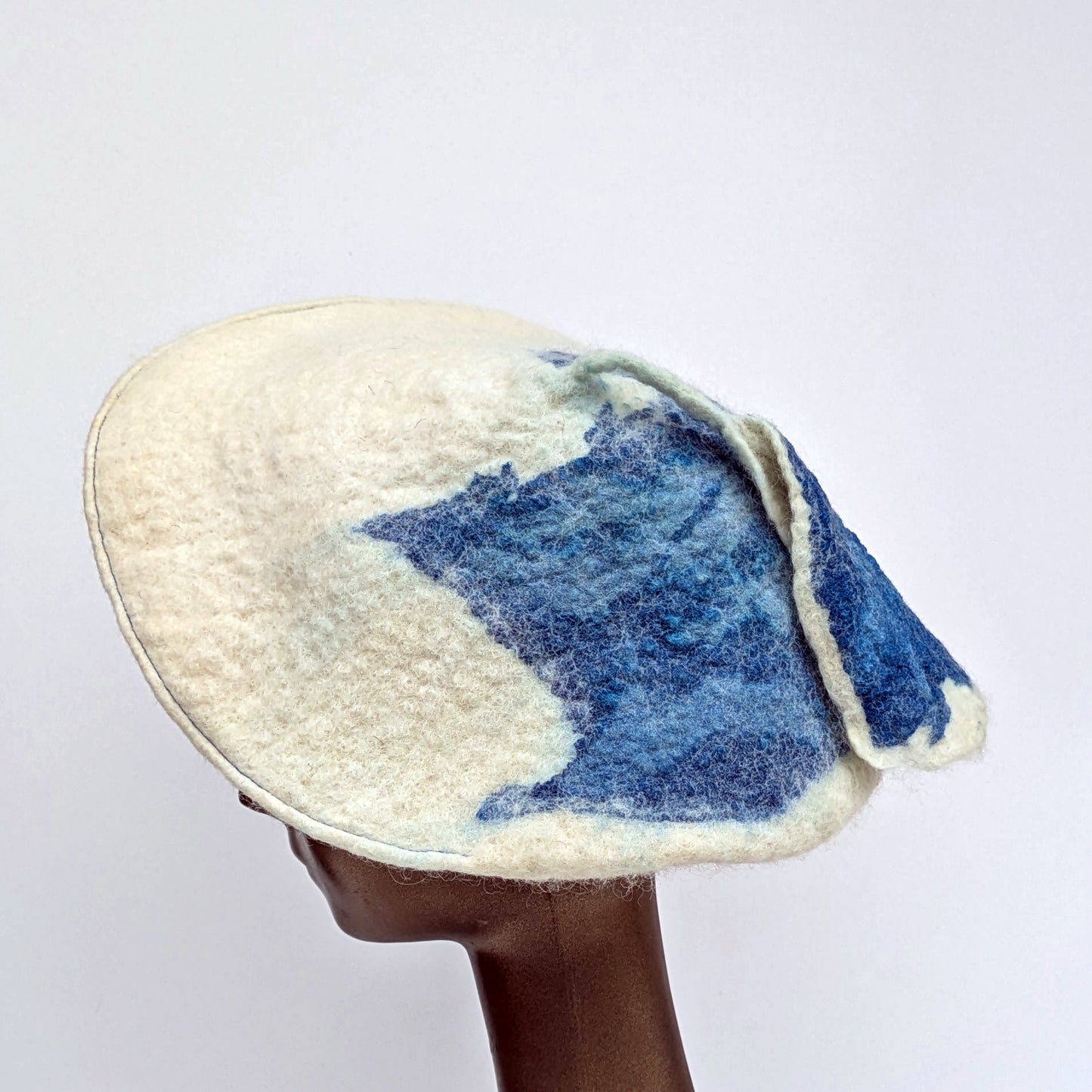 Felted White Beret with blue coloured seaweed print, worn on mannequin -Side view