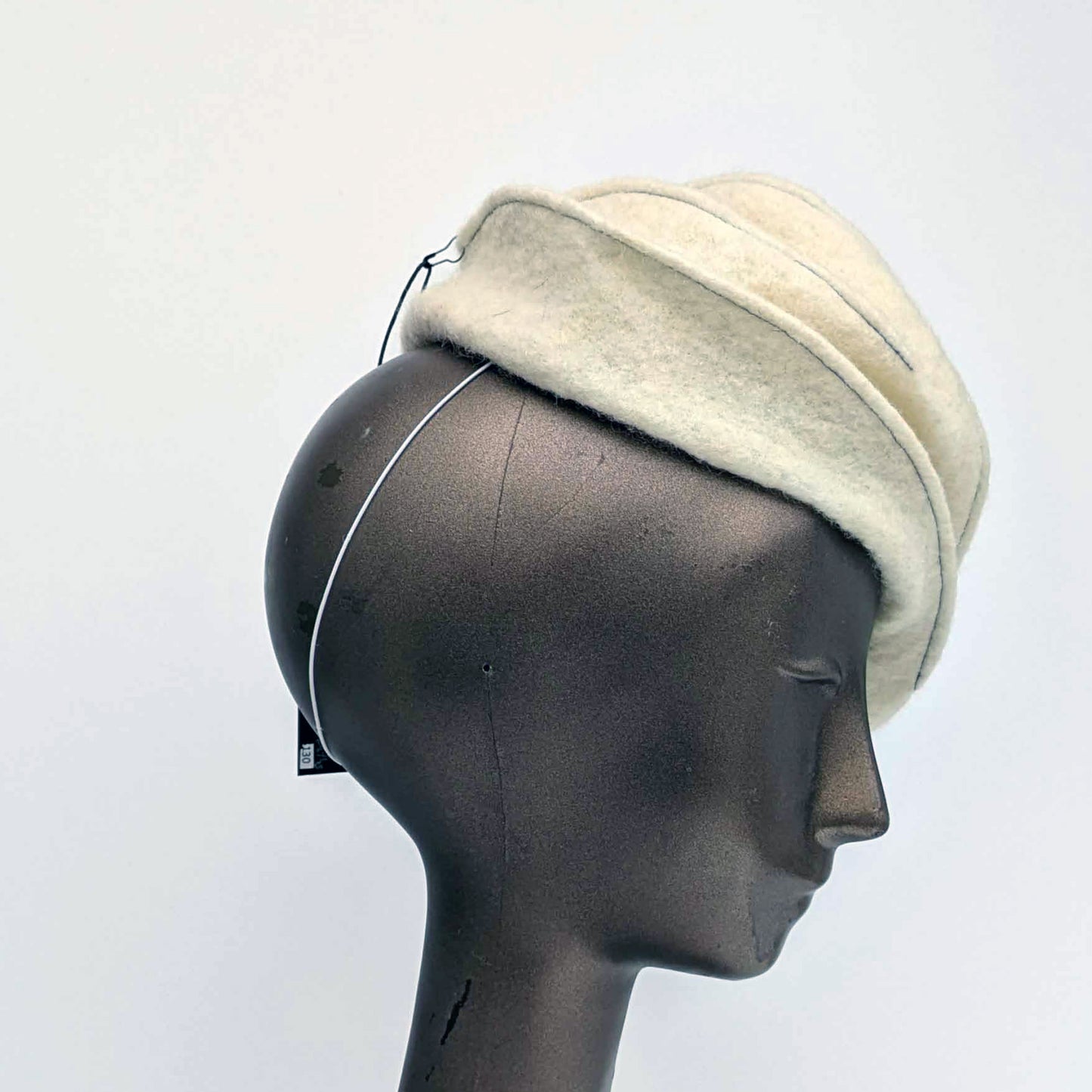 Cream coloured felt fascinator with topstitching -side view.