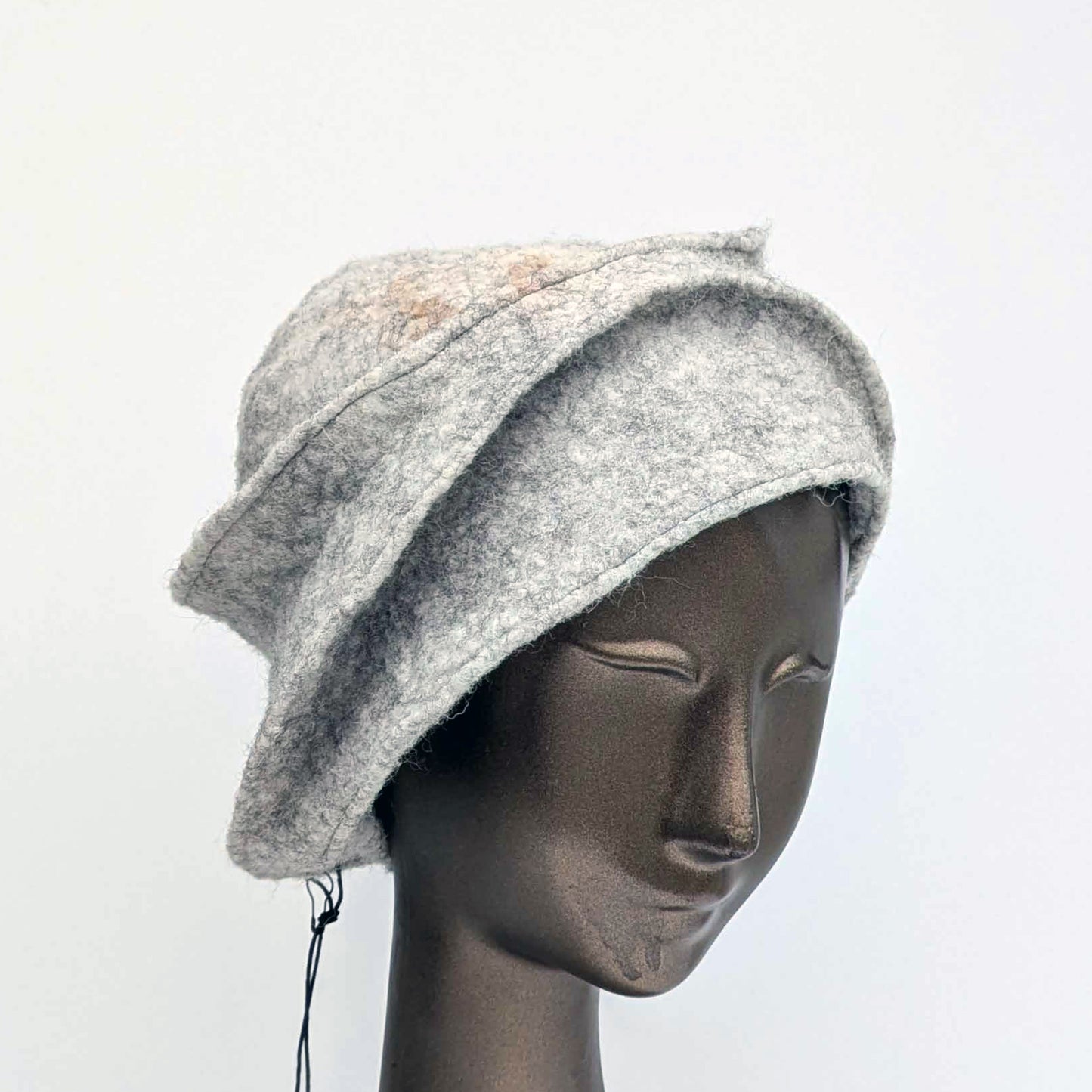 Grey bucket hat on a mannequin head against a white background - three-quarters view.