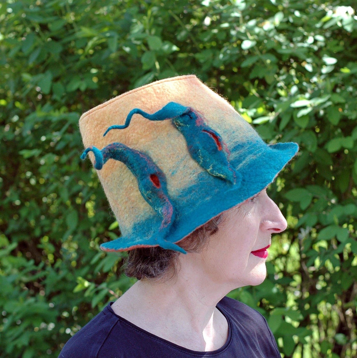 Almost Classic Yellow Fedora with Organic Shaped Pods- side view against green shrubs