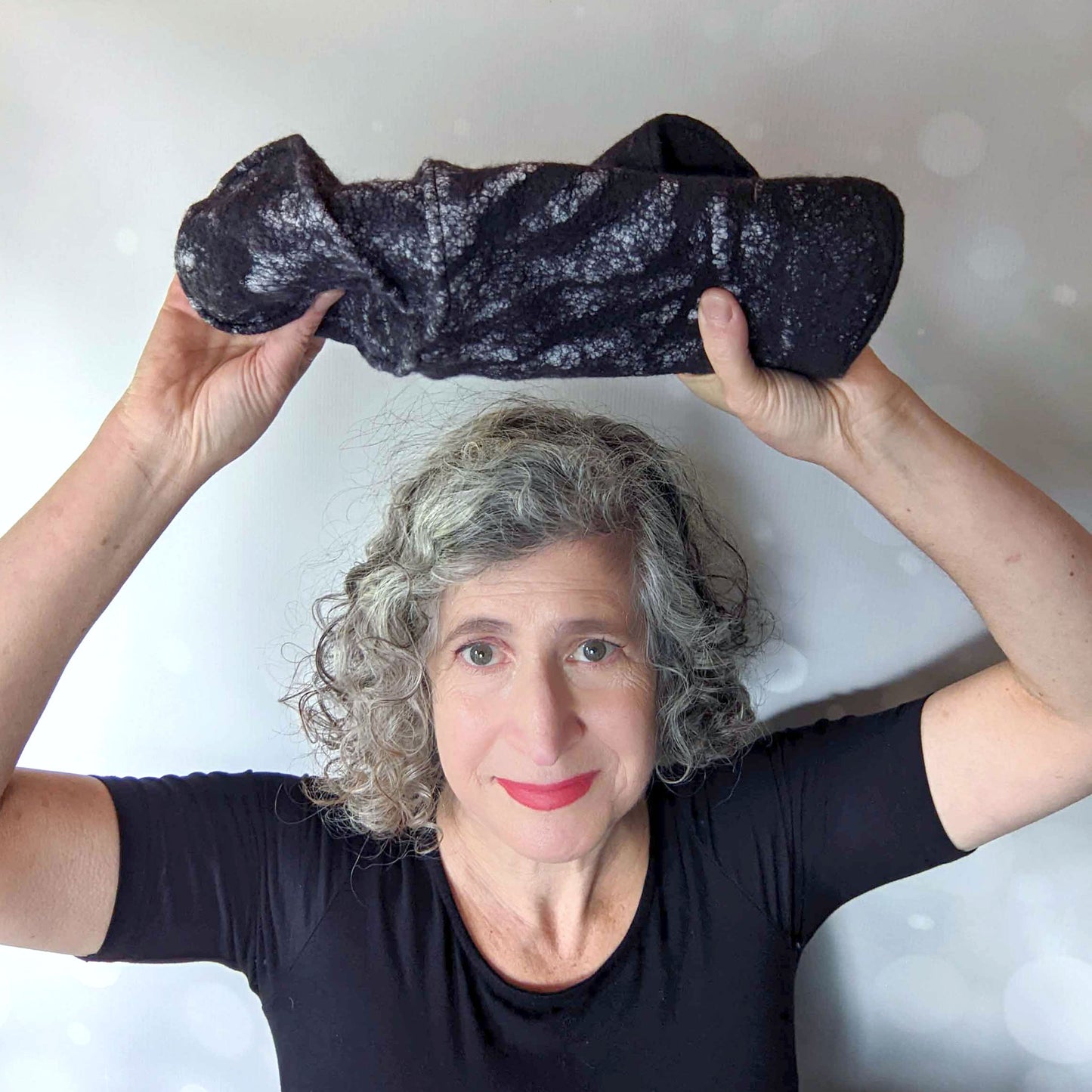 Showing how Nuno Felted hat can be rolled up to pack for travel.