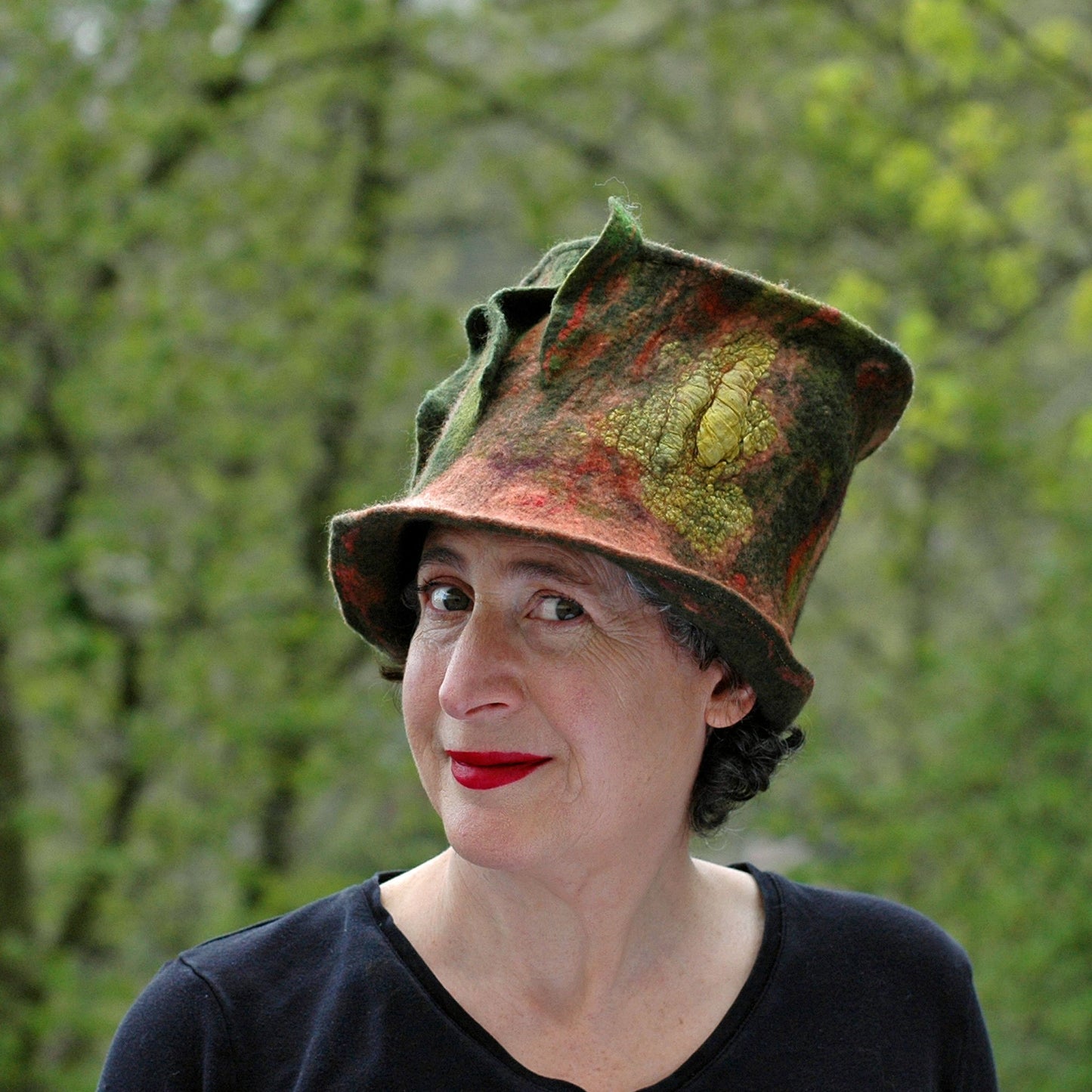 Green and Orange Felted Top Hat with Vertical Ruffles - against the trees