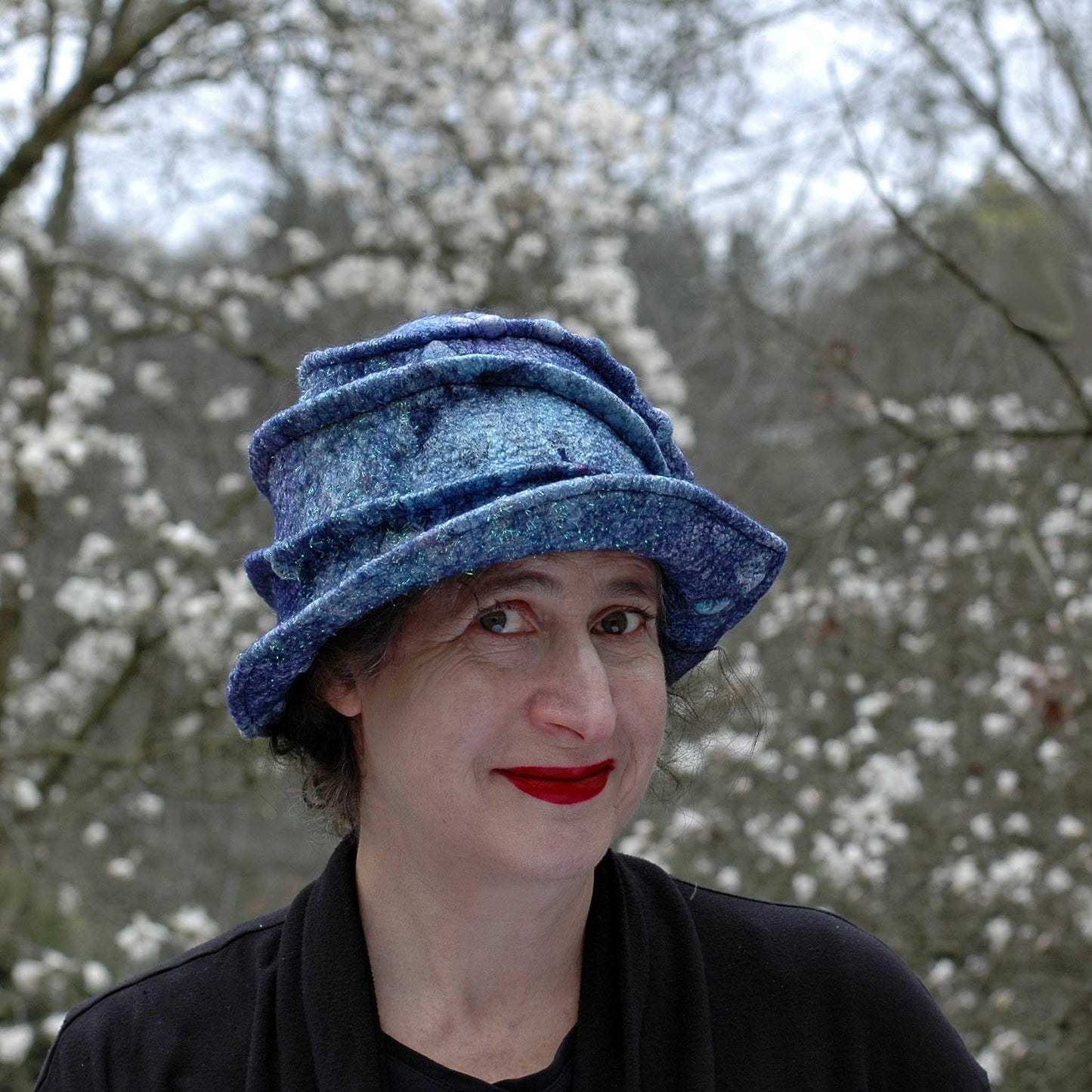 Iridescent Blue Violet Bucket Hat against magnolia blossoms.