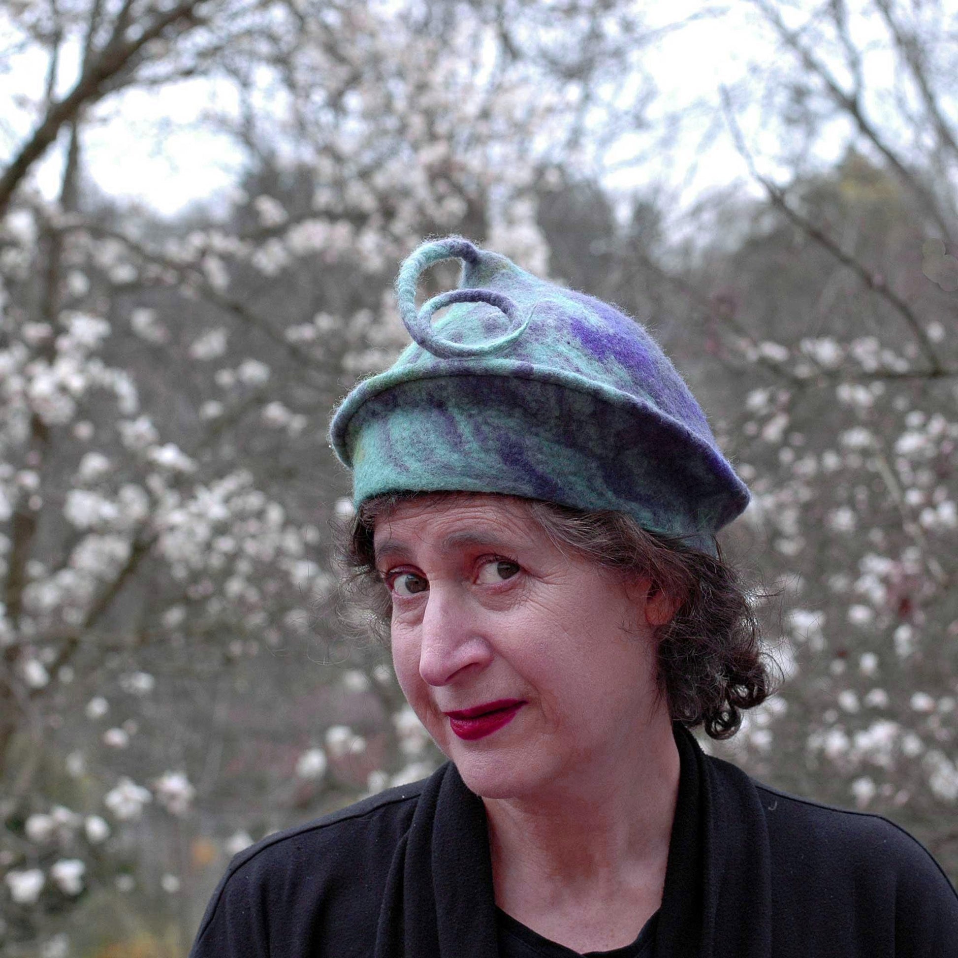 Lavender and Green Curlicue Beret against the magnolia blossoms.