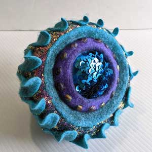 Sculptural Felted Pod in turquoise made of wool and sequin fabrics with Judit Pocs online workshop - Form within a Form.