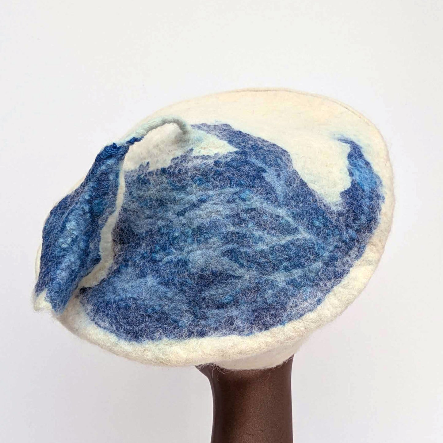Organic blue bird-shaped print on creamy white beret - with blue tassel stem.
