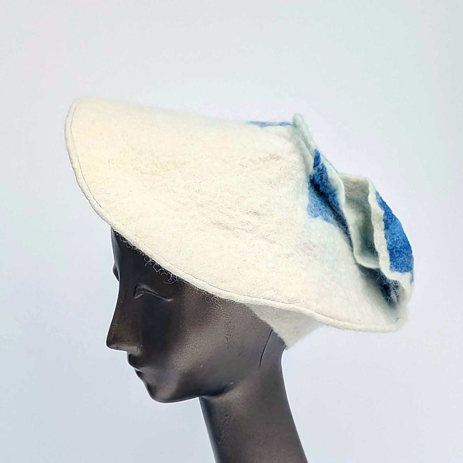 Felted White Beret with angle worn on mannequin - with Cyanotype blu seaweed tassel.