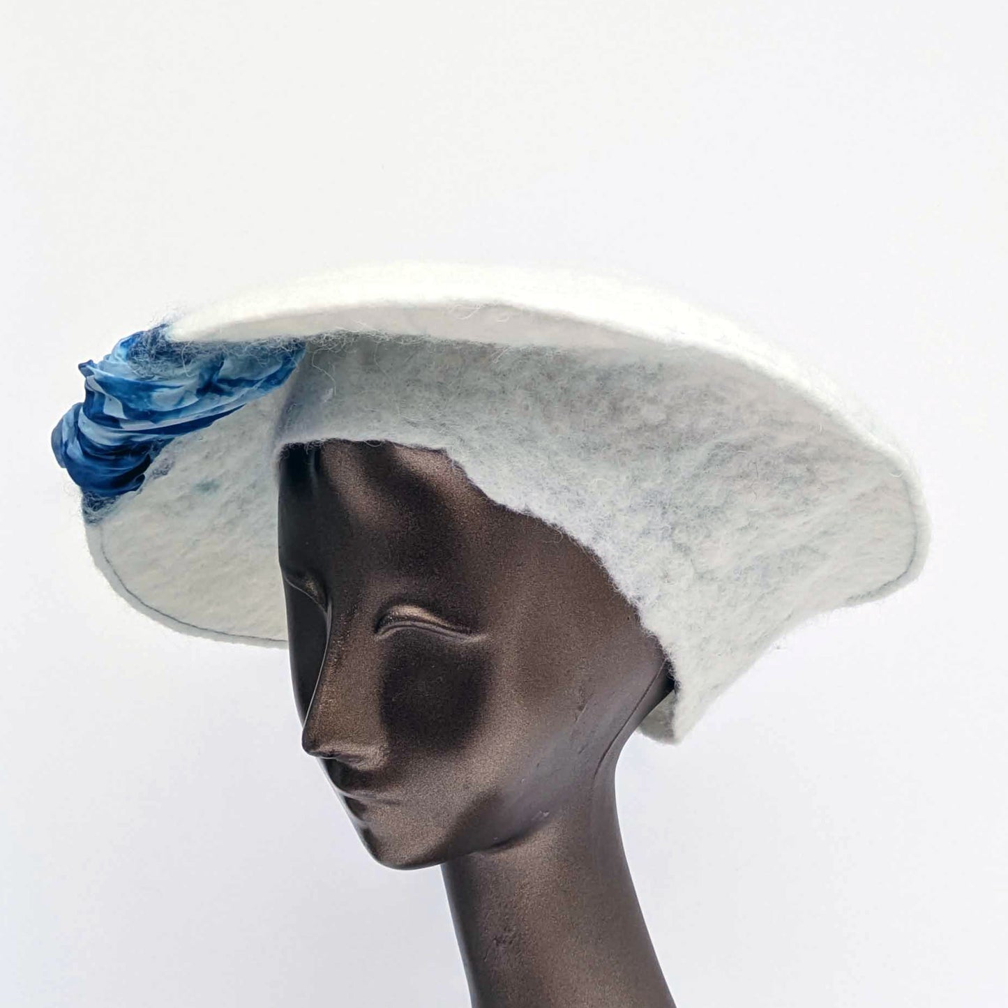 White felted saucer hat with cyanotype printed blue ruched fabric - three quarters view