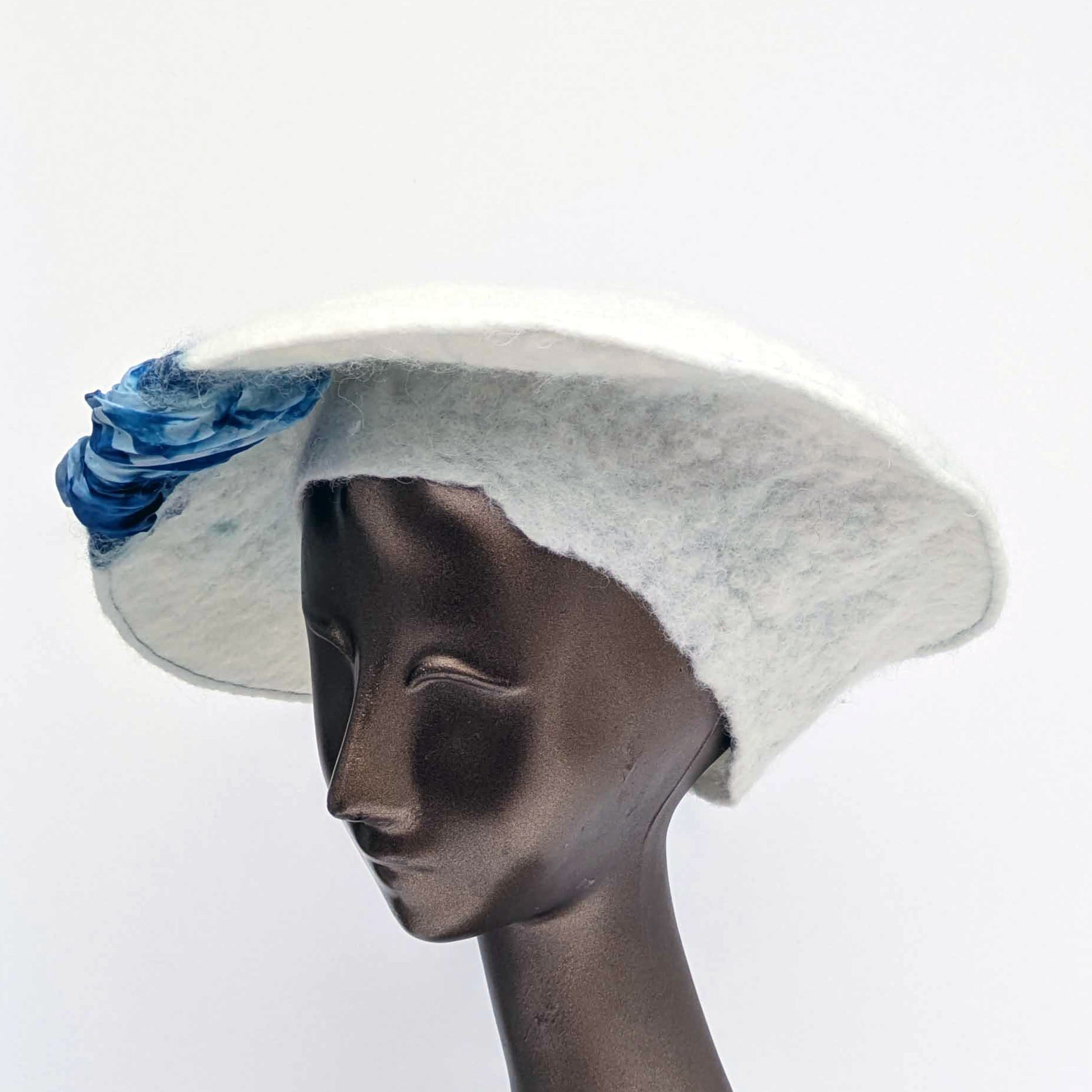 White felted saucer hat with cyanotype printed blue ruched fabric - three quarters view