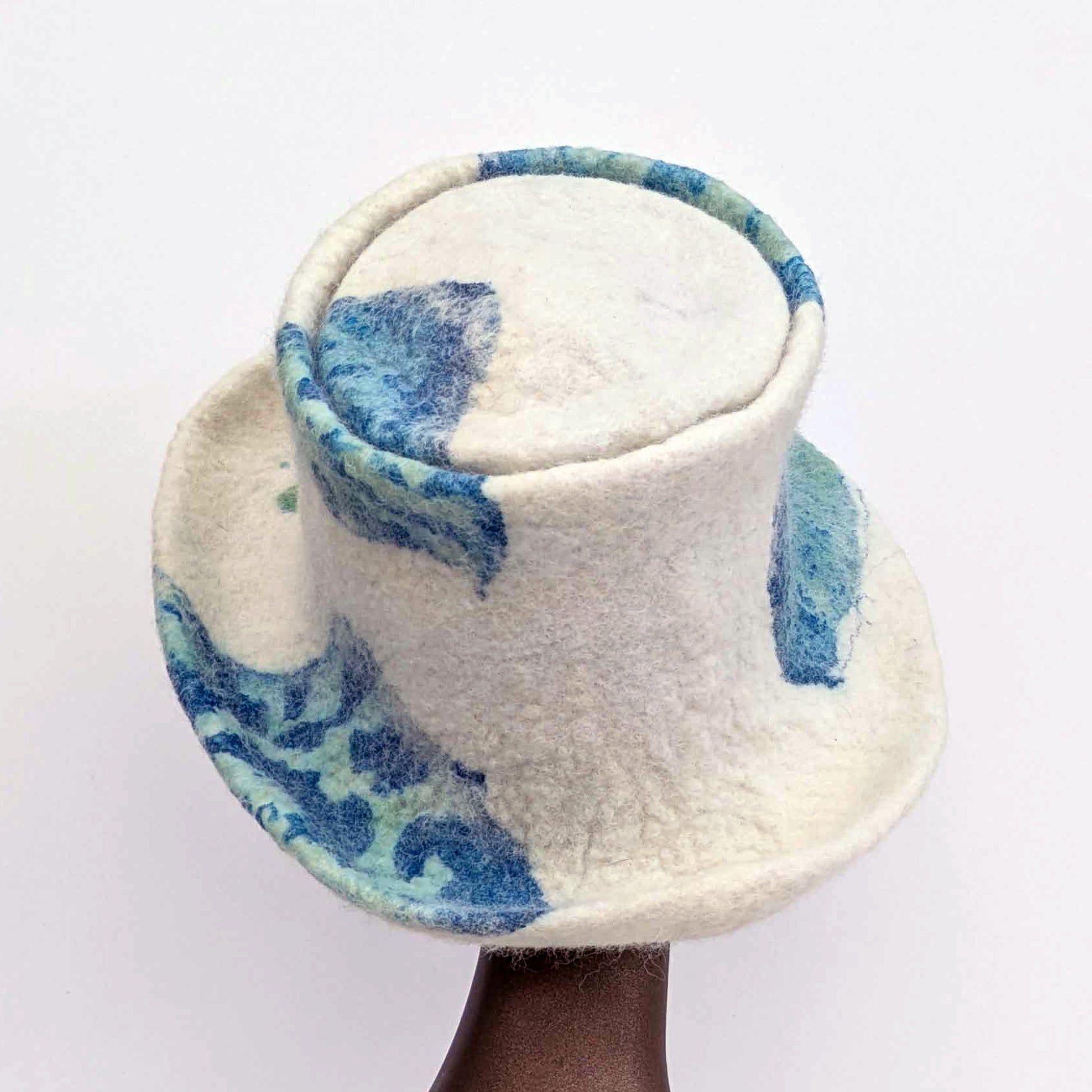Cream-coloured top hat with wide brim and sage green seaweed print against blue Cyanotype - back view