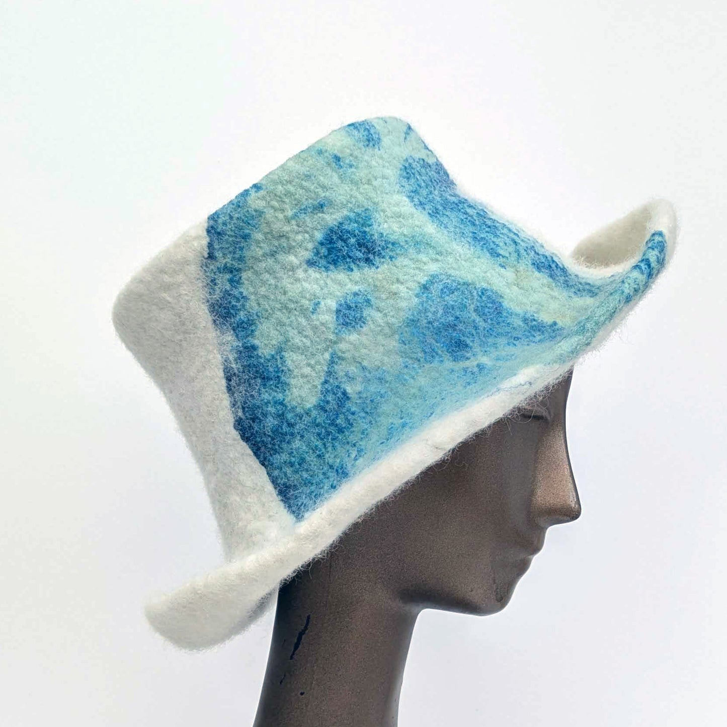 Cream-coloured top hat with wide brim and sage green seaweed print against blue Cyanotype - side view
