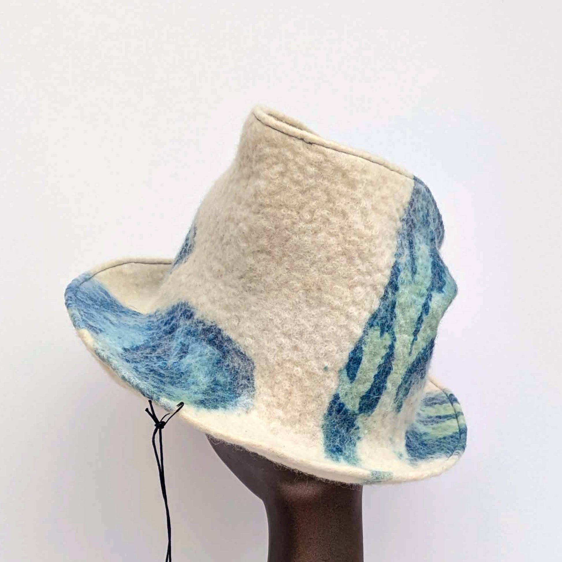 "Crushed' tip, Fedora hat with blue and green pattern on a mannequin head against a white background -backview