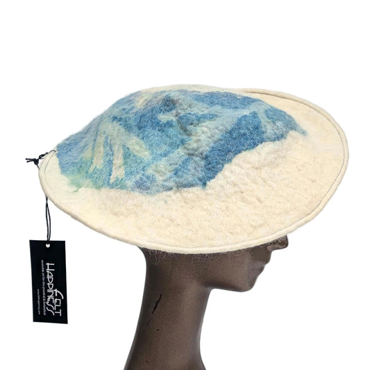 Cream coloured saucer beret hat with blue seaweed Cyanotype print on the tip - worn by a mannequin. Sideview.