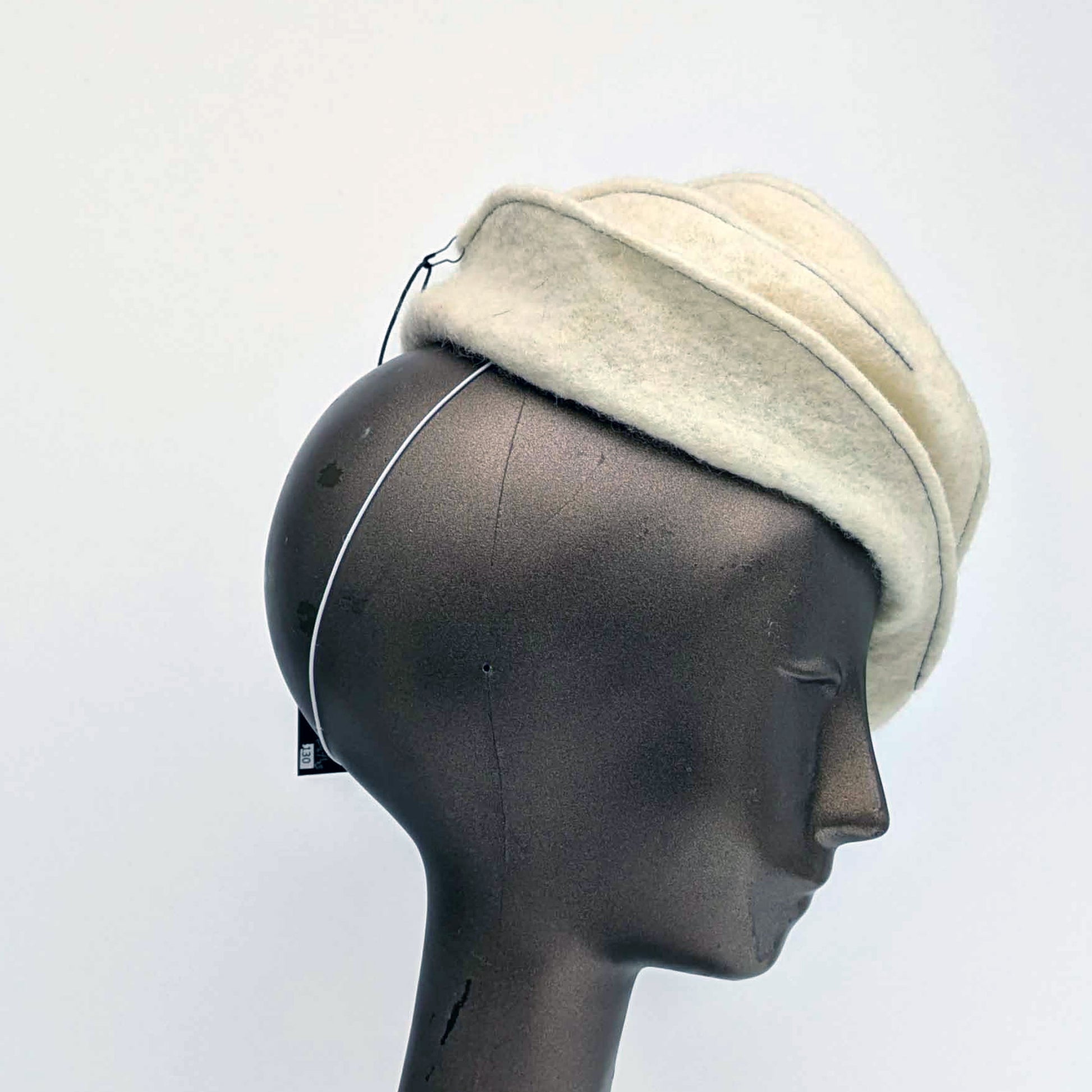 Cream coloured felt fascinator with topstitching -side view.