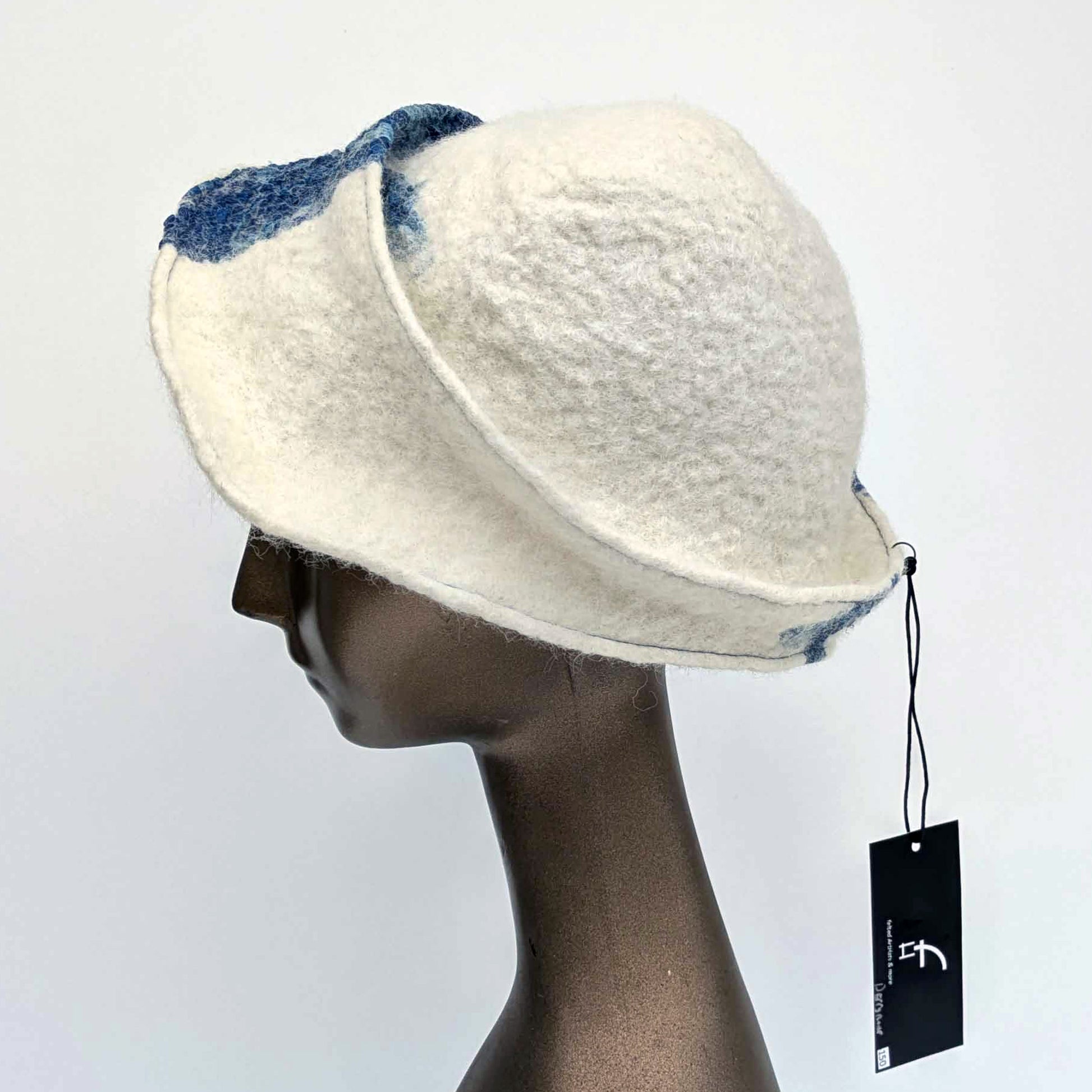 White cap with small bill and blue decorative elements on a mannequin head against a white background - side view