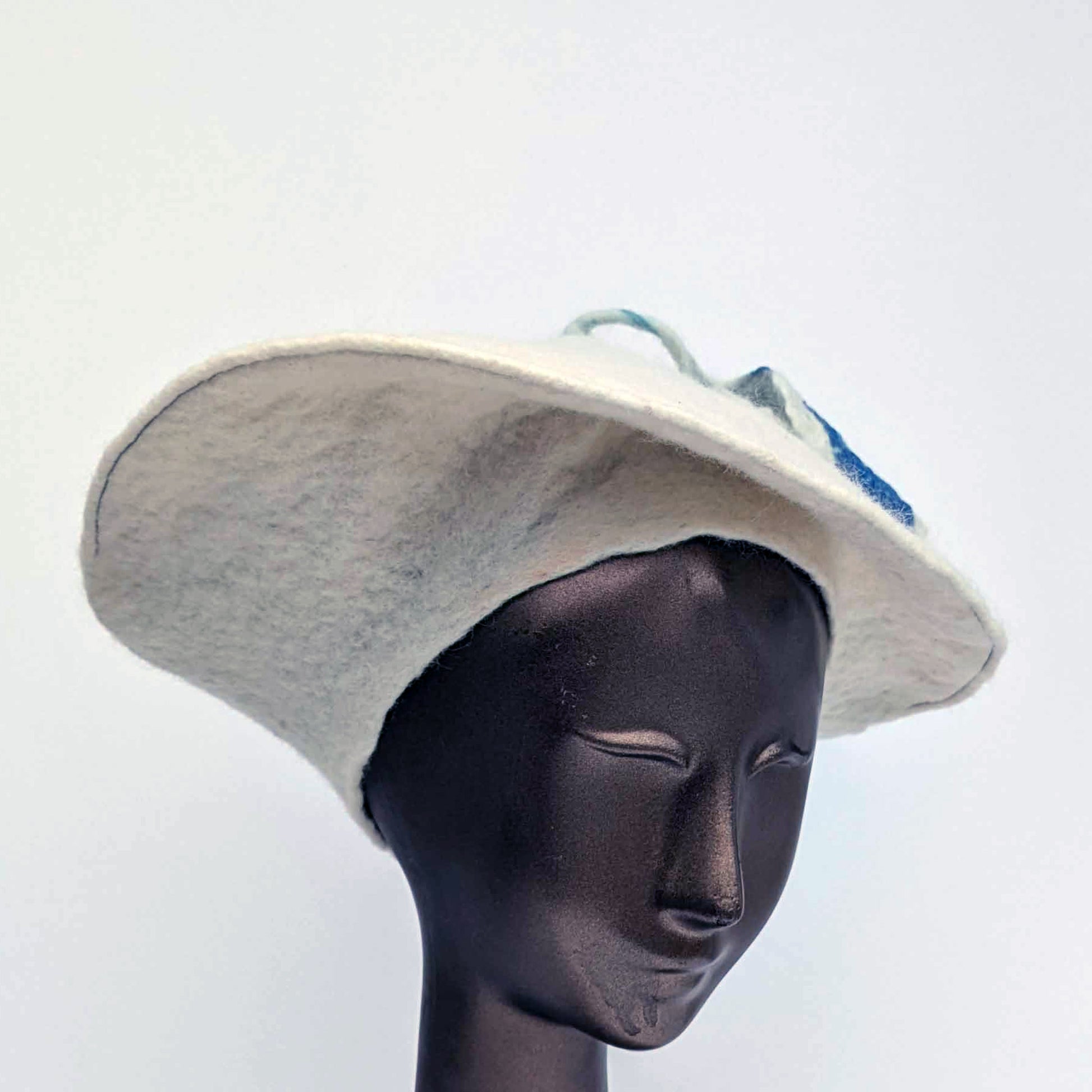 White felted beret with blue tassel on top - worn by mannequin