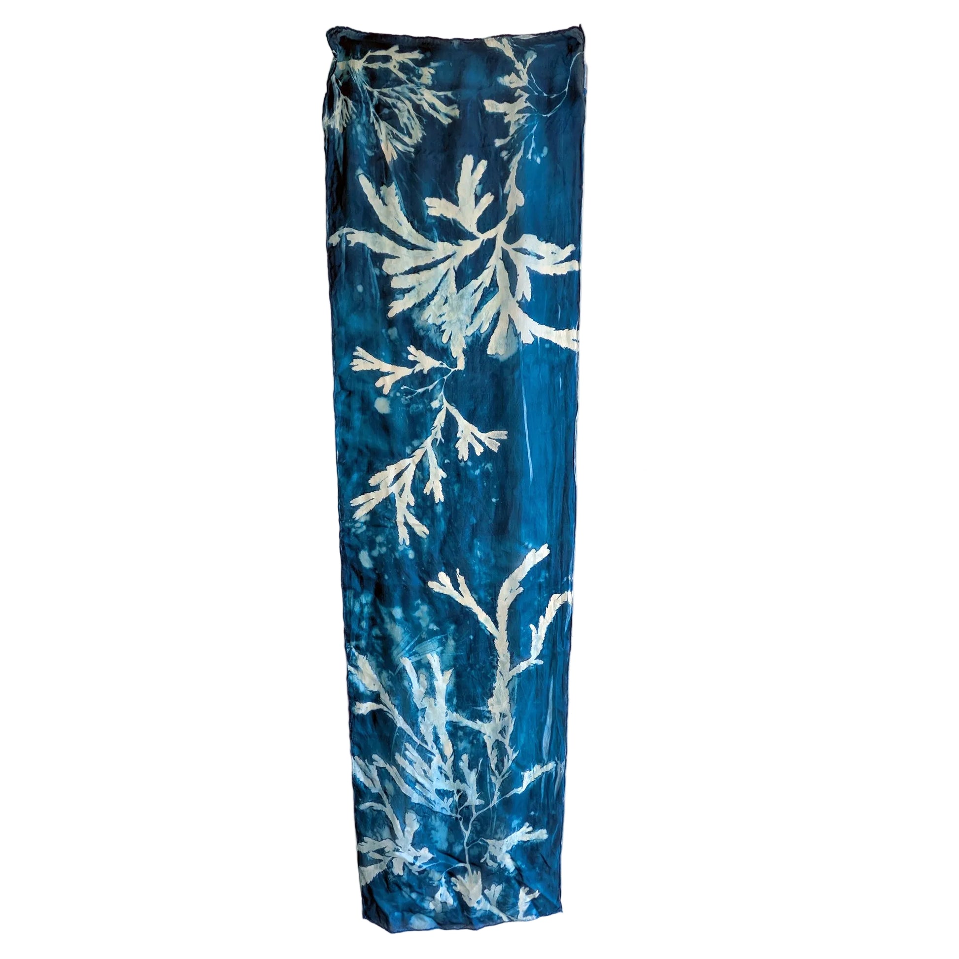 Blue rectangular scarf with white leaf pattern on a white background