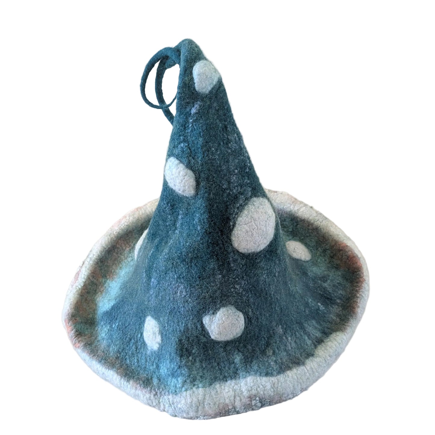 A felt mushroom-shaped hat or hat-like accessory in dark teal-blue with large white spots and a white fuzzy edge, displayed against a plain white background.