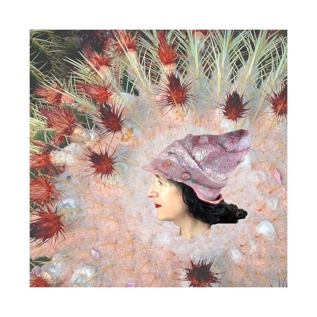 Hat digitally collaged on to the tip of a pink and red cactus.